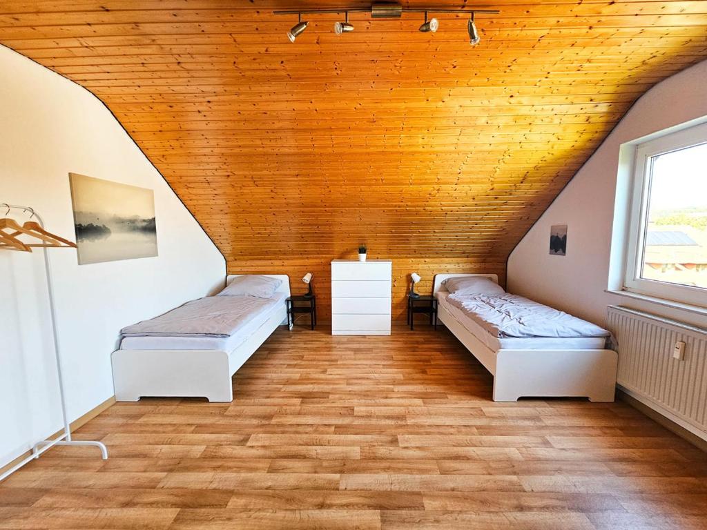 2 camas en una habitación con techo de madera en Cozy Apartment in Klein-Winternheim, en Klein-Winternheim