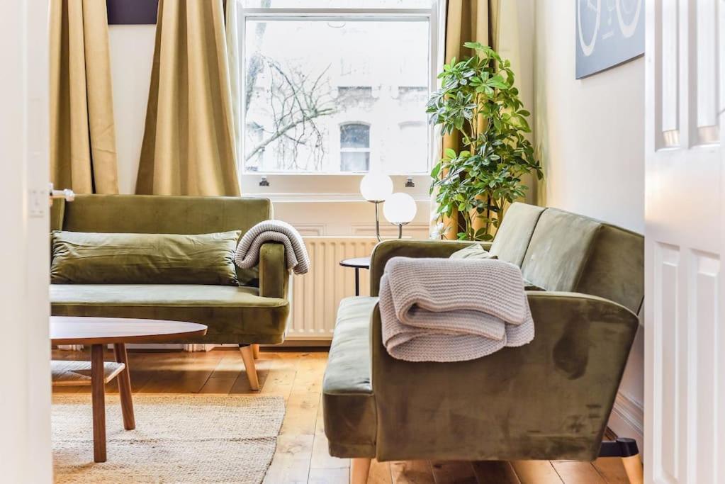 sala de estar con 2 sillas verdes y mesa en Knightsbridge Stylish Two Bedroom Apartment, en Londres