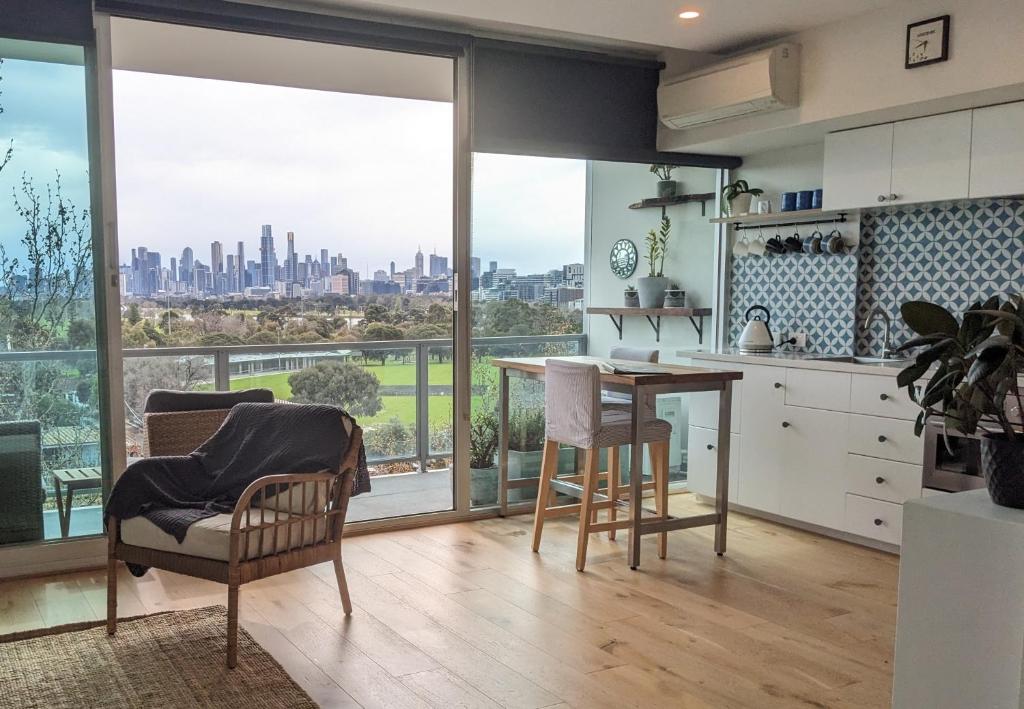 メルボルンにあるSpectacular Sunset Hideaway BestView St Kilda boutique self-contained luxury apartmentの市街の景色を望むキッチン(テーブル、椅子付)