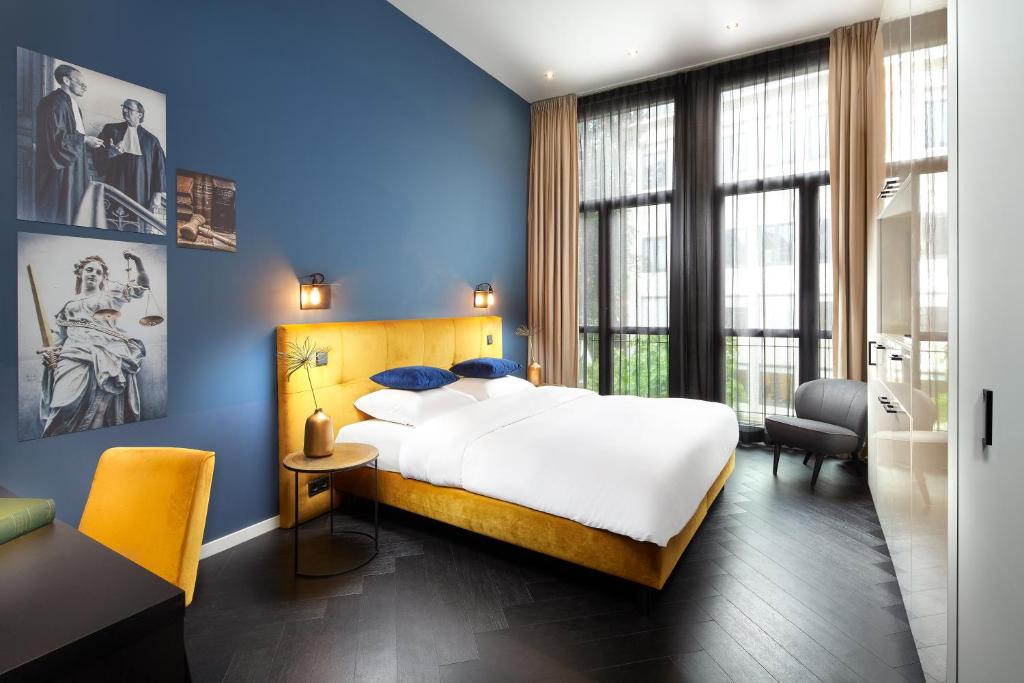 a bedroom with a large bed and blue walls at Court Hotel Utrecht City Centre in Utrecht