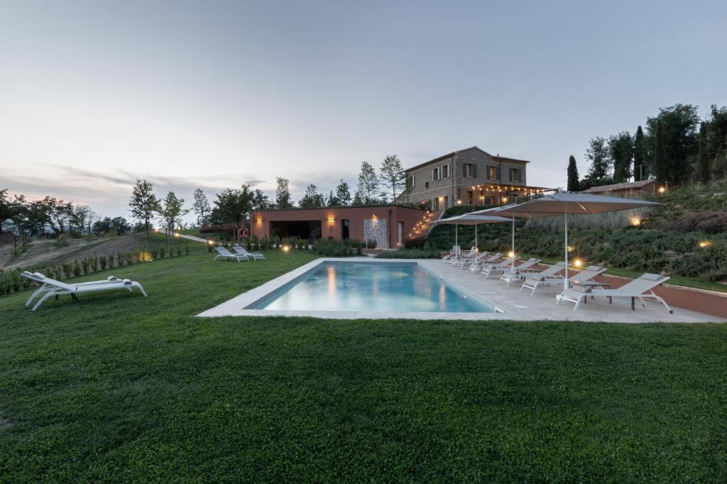 a pool in a yard with chairs and a house at Agriturismo Corbaia Relais in Santa Lucia di Roversano