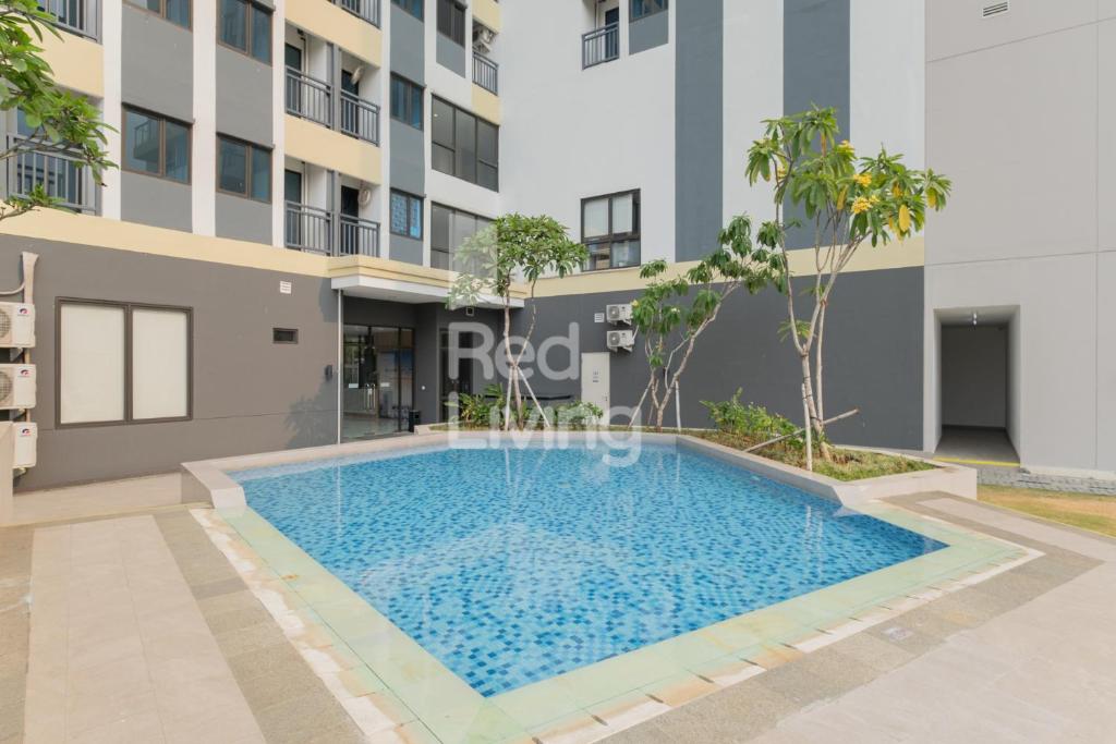 a swimming pool in front of a building at RedLiving Apartemen Jakarta Living Star - BoboRooms in Jakarta