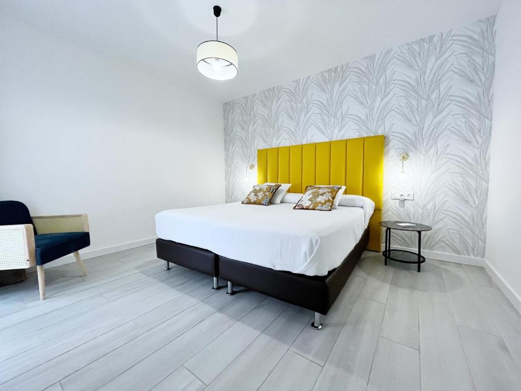 a bedroom with a large bed and a yellow headboard at Casa Relán by FTV HOLIDAYS HOMES in Villaverde