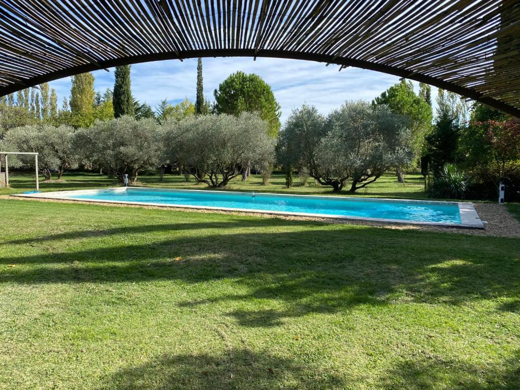 una piscina en un campo de césped con árboles en Mas des Bômes ****, en Mérindol