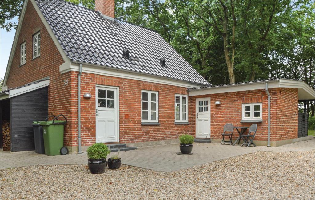 una casa de ladrillo con un patio delante de ella en Gorgeous Home In Tistrup With Kitchen, en Tistrup