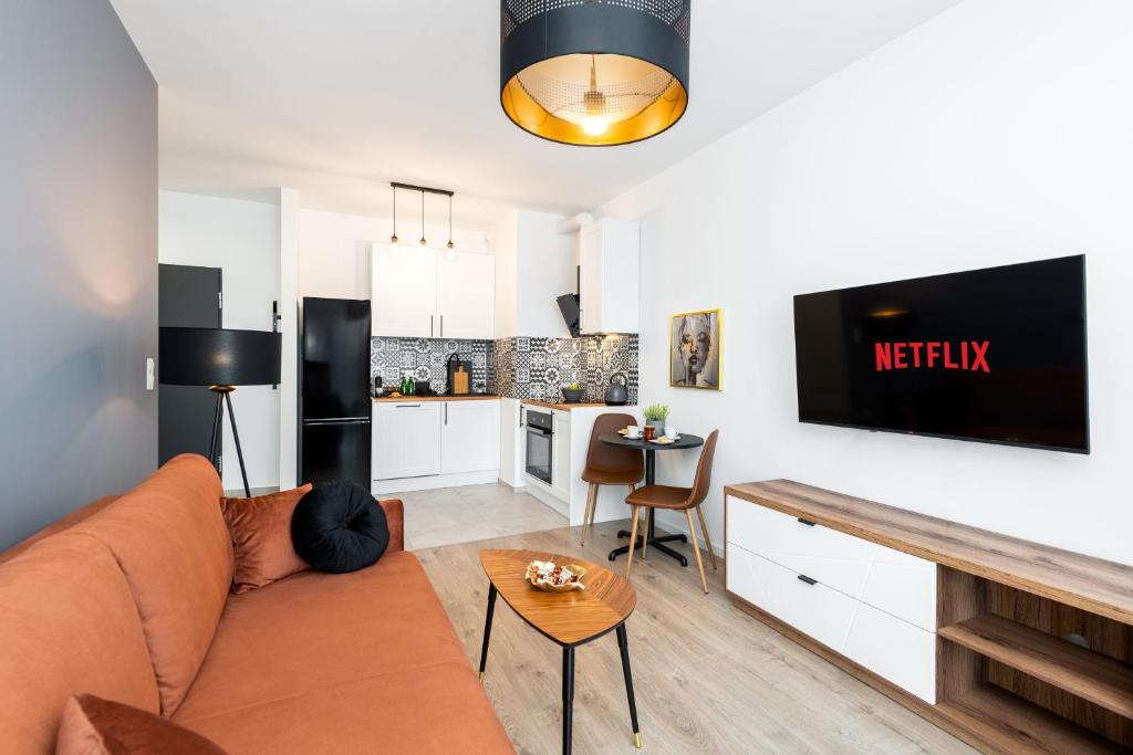 un soggiorno con divano e cucina di Kairos Apartments -Tower II Premium - darmowy parking, siłownia, sauna - ścisłe centrum a Katowice