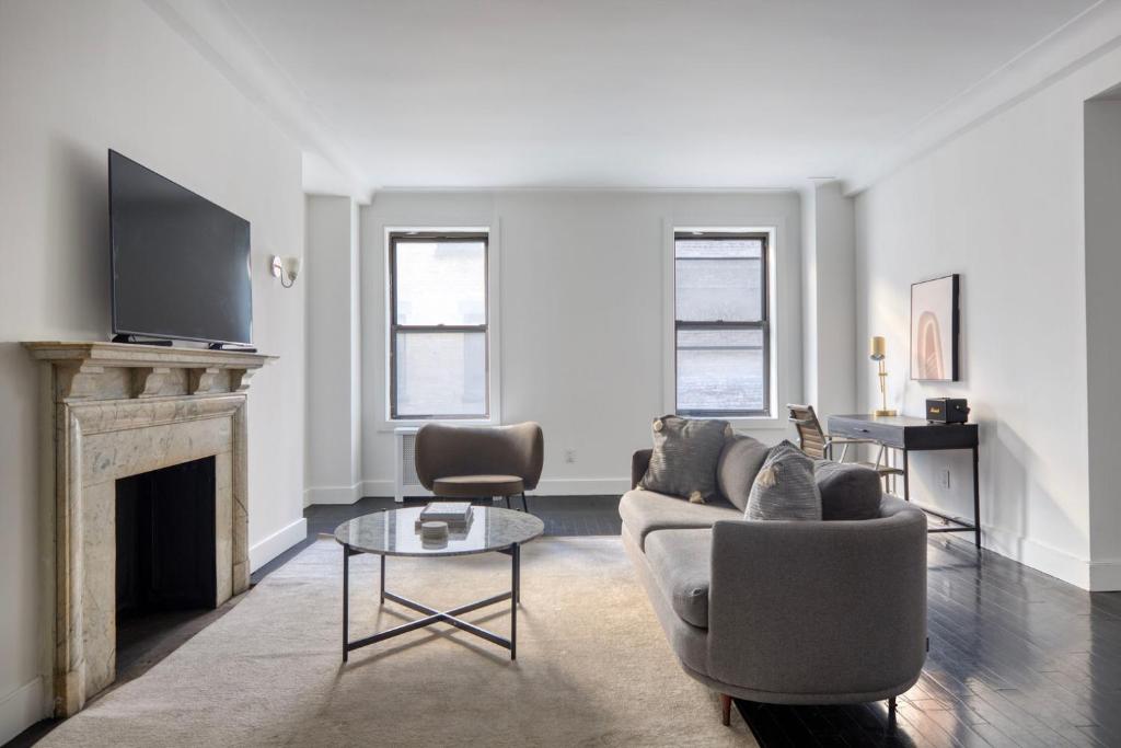 a living room with a couch and a fireplace at Midtown 2br w doorman wd nr Central Park NYC-1246 in New York