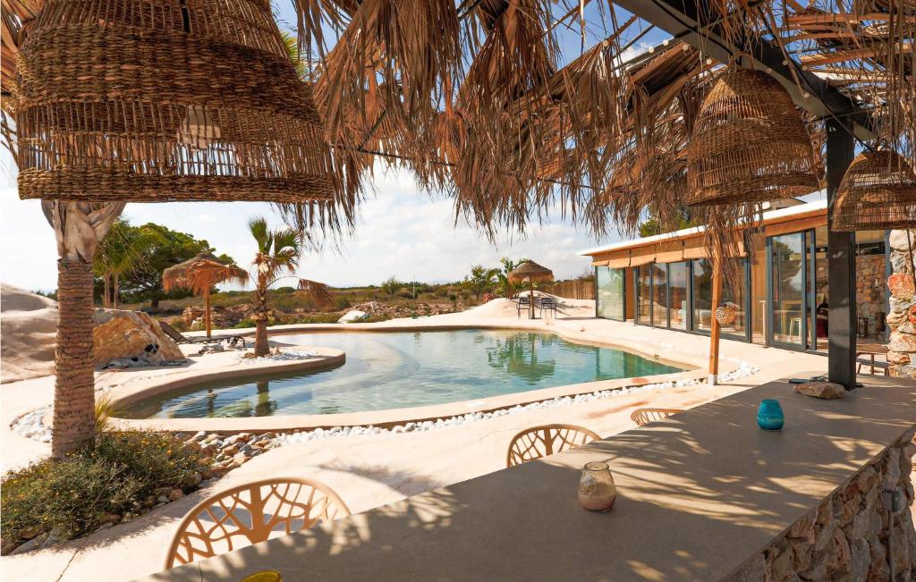 a swimming pool in a resort with a table and chairs at House Near Golf Course in Murcia