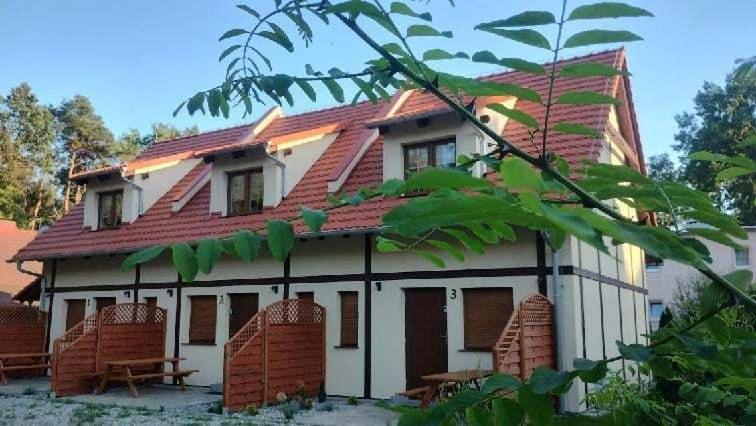una casa con techo rojo encima en Leśne Wzgórze przy Zamkowej, en Lubniewice