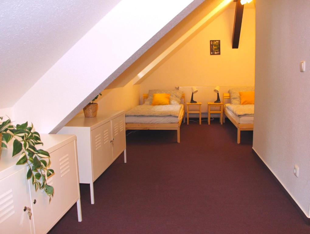 a attic room with two beds and a staircase at Stadtwohnung in Calau (Spreewald) in Calau