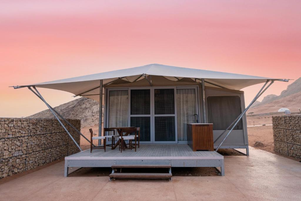 a tent with a table and a chair in the desert at Moon Retreat by Sharjah Collection in Sharjah