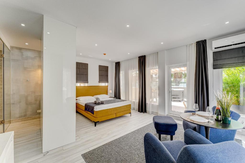 a bedroom with a bed and a table and chairs at BAL Apartments Adults Only in Arona