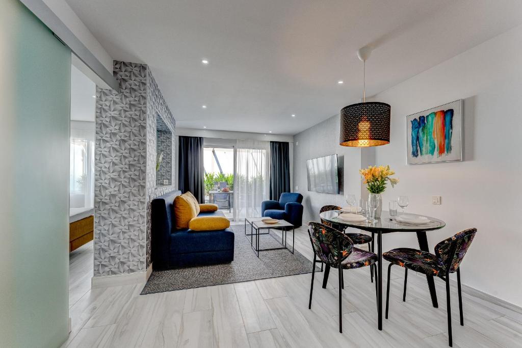 a living room with a table and a dining room at BAL Apartments Adults Only in Arona