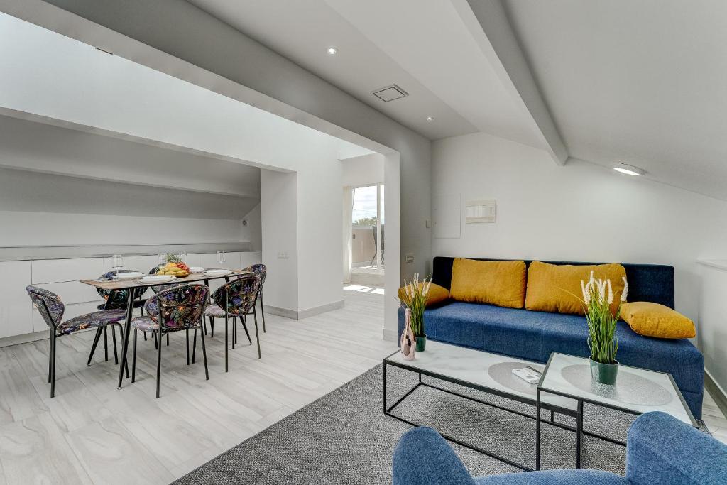 a living room with a blue couch and a table at BAL Apartments Adults Only in Arona