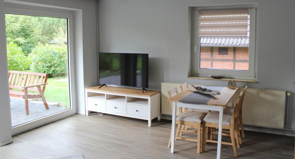 a living room with a television and a table and chairs at Ferienhaus Strandnah - Wohnung 1 in Otterndorf
