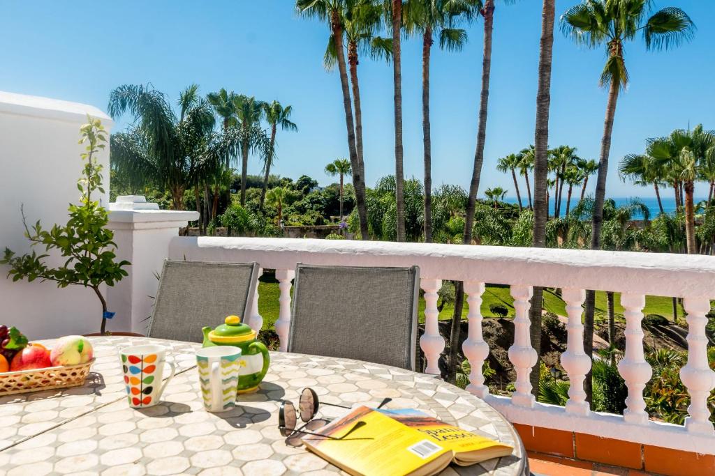 una mesa con fruta en un balcón con palmeras en Casablanca 50 Oasis Properties, en Nerja
