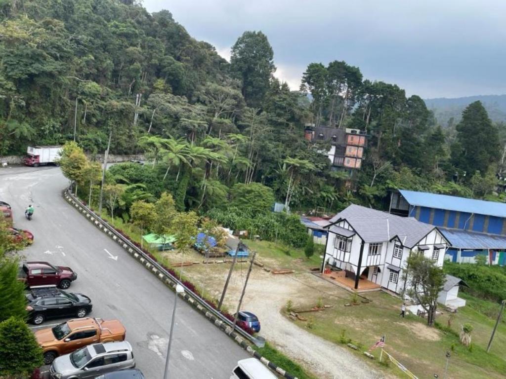 a street with cars parked on the side of a road at Hanna Homestay Apartment for Muslim in Tanah Rata