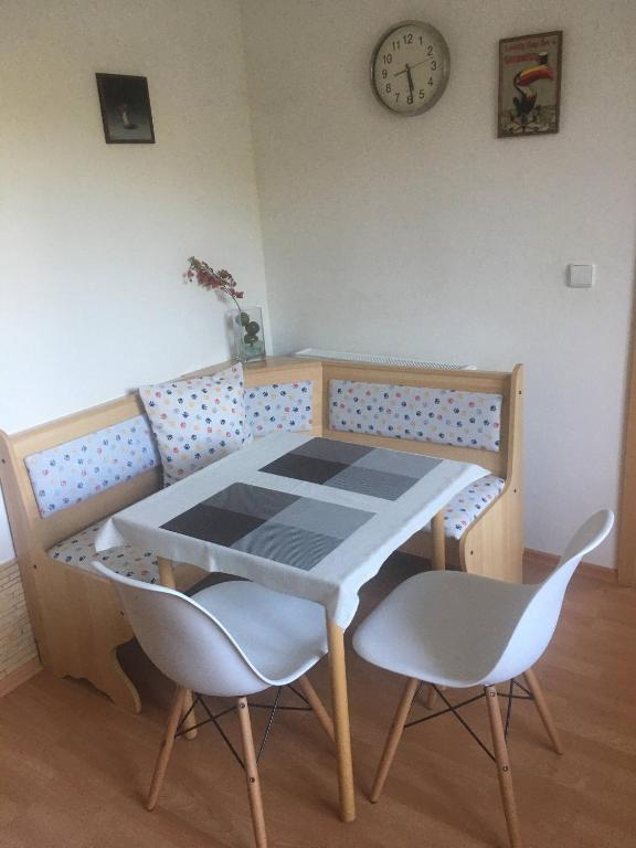 stół i krzesła w pokoju z zegarem na ścianie w obiekcie Apartmán Horní Lipová w mieście Lipova Lazne