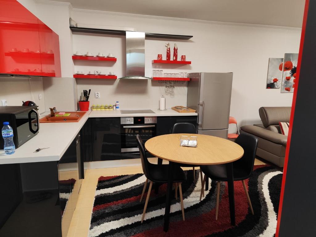 een keuken met een tafel en stoelen en een bank bij Апартамент "Red&Black" в Гранд Манастира - Пампорово in Pamporovo