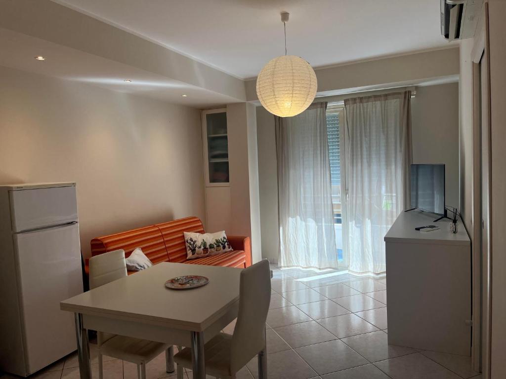 eine Küche und ein Wohnzimmer mit einem Tisch und einem Esszimmer in der Unterkunft casa vacanze La Farfalla in Capo dʼOrlando