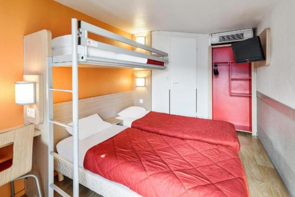 a bedroom with a bunk bed with a red blanket at Premiere Classe Creil - Villers Saint Paul in Villers-Saint-Paul