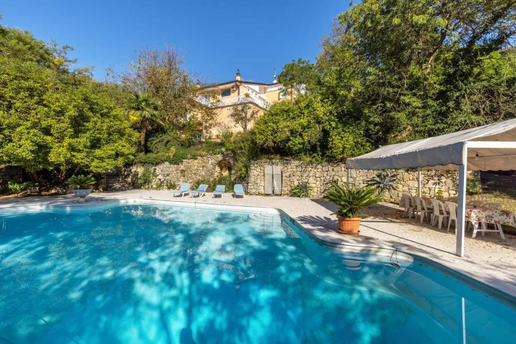 a swimming pool with chairs and a house in the background at Villa Magnolia in Arcugnano
