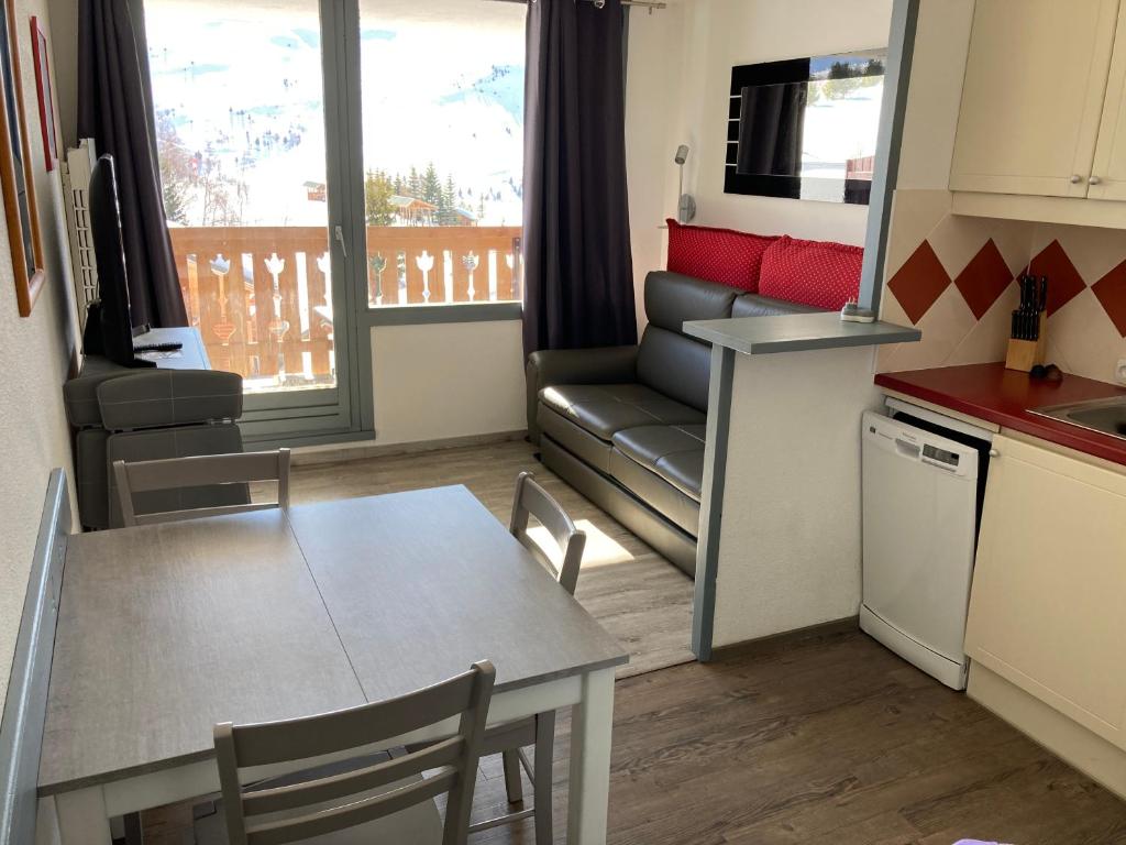 Il comprend une cuisine et un salon avec une table et un canapé. dans l'établissement Appartement 5 pers Résidence Les Mélèzes quartier les Bergers Alpe d Huez, à L'Alpe-d'Huez