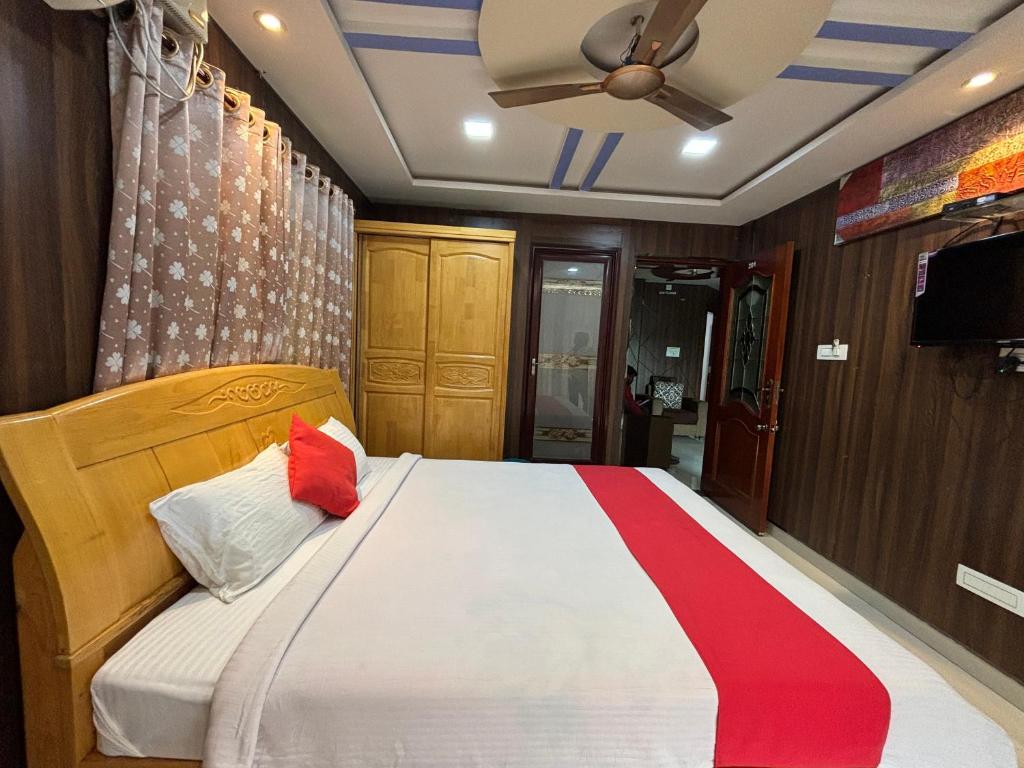 a bedroom with a bed with a red stripe on it at STAYMAKER DV Residency in Bhadrāvati