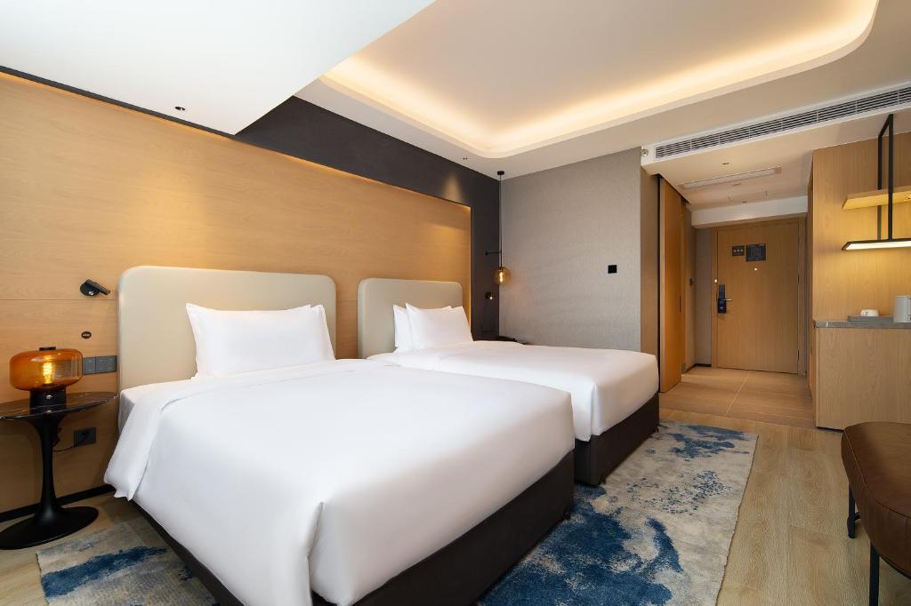 Postel nebo postele na pokoji v ubytování Langham Honor International Hotel Canton Fair Complex Branch - Free Shuttle to Canton Fair Complex During Canton Fair Period & Free Mini Bar