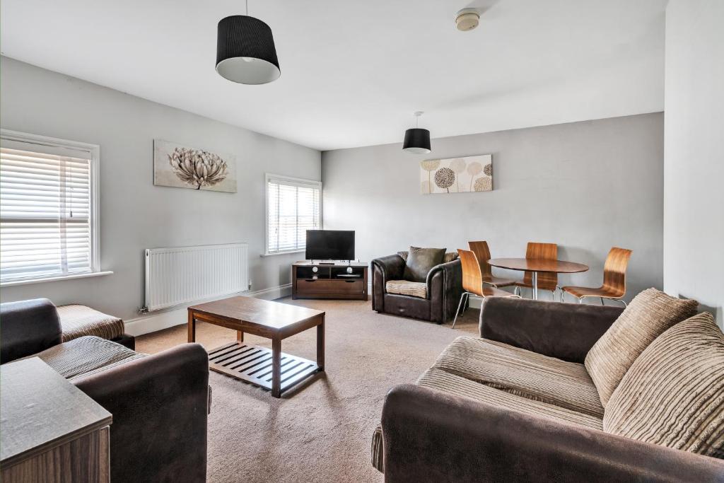 a living room with couches and a table at Cool and Chic Duffield Road Apartments in Derby