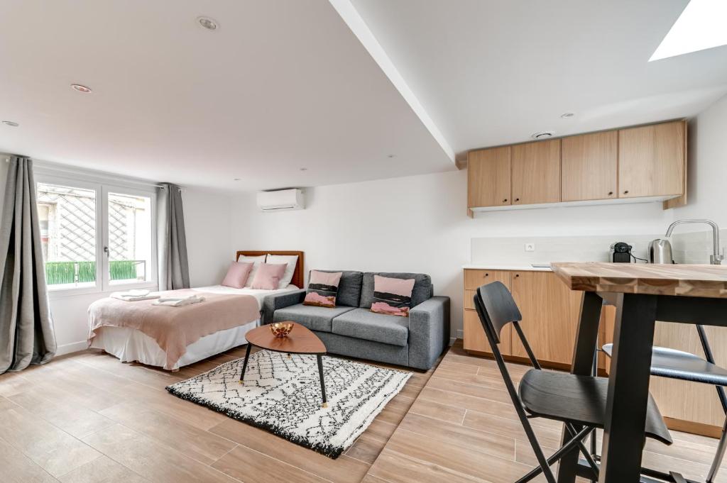 un soggiorno con letto e divano di 136 Suite Harold - Superbe Appartement à Paris. a Parigi