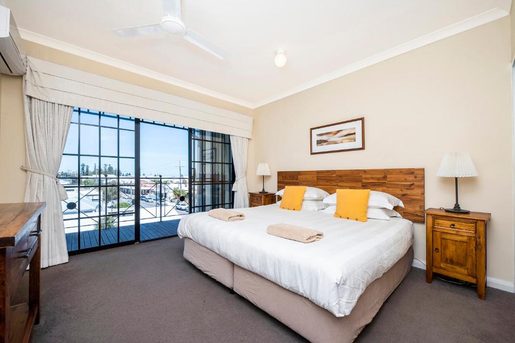 a bedroom with a large bed and a large window at Ocean Sunsets - 2 bedroom converted warehouse apartment in Fremantle