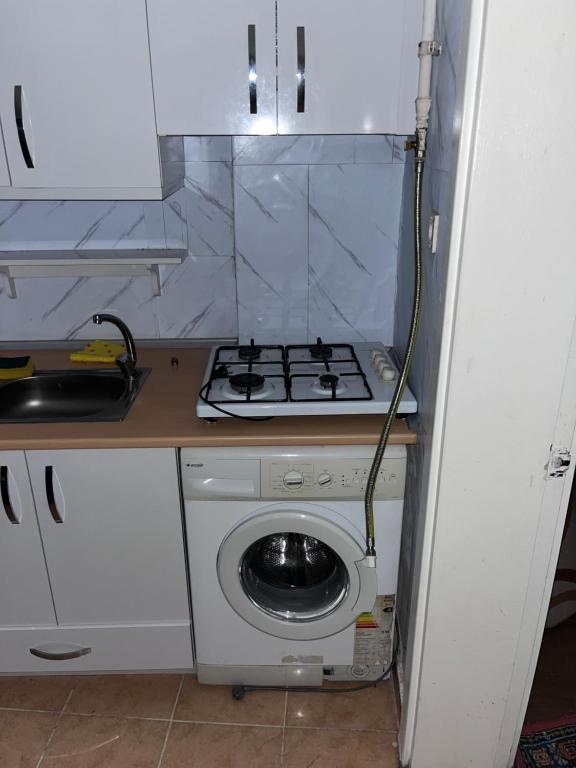 a kitchen with a stove and a washing machine at Fatih Eco 3 Apart in Istanbul