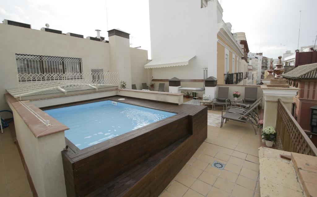 a hot tub on the roof of a building at Apartamentos Plaza Nueva in Seville