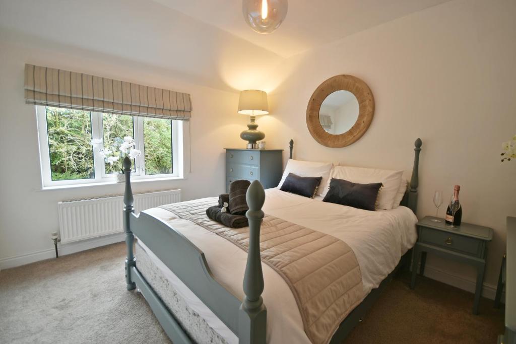 Schlafzimmer mit einem Bett und einem Spiegel in der Unterkunft Pendle Hill Farm - 5* Luxury, Log fire, Parking in Burnley