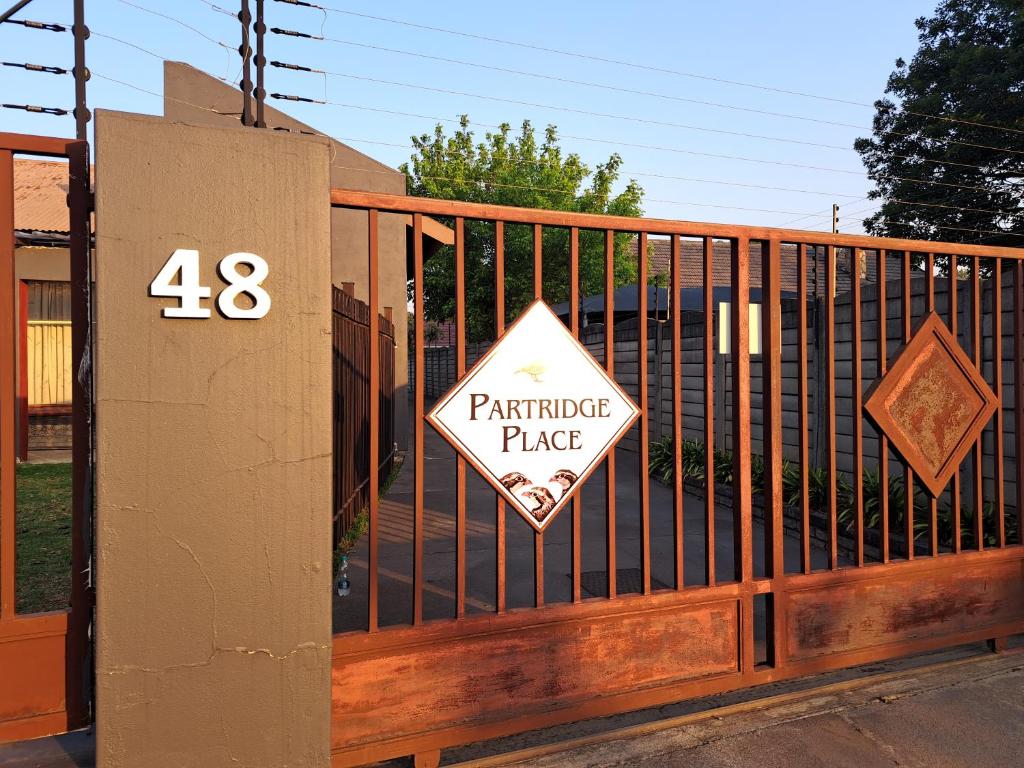 a gate with a parking place sign on it at Partridge Place in Kempton Park