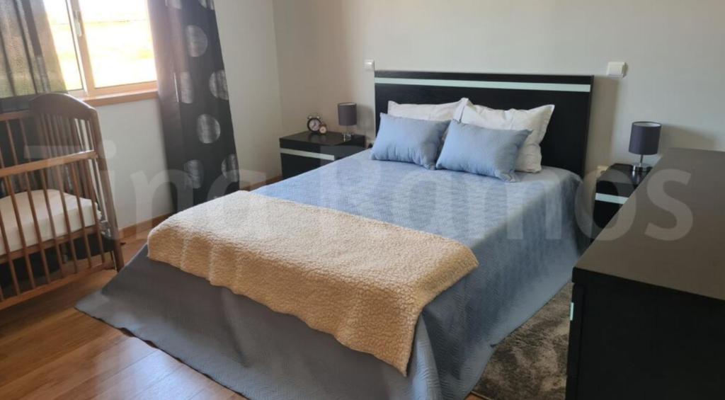 a bedroom with a bed with blue sheets and pillows at Casa Ramos in Póvoa de Varzim