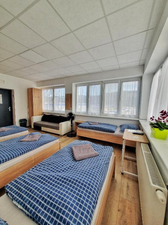 Habitación grande con 3 camas y sofá. en UBYTOVŇA BYTČA, en Bytca