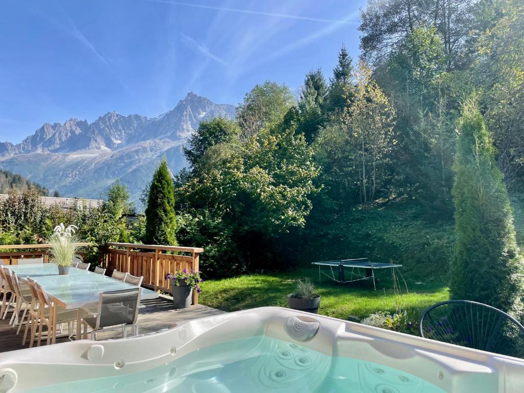 a hot tub in a backyard with mountains in the background at 13 personnes,jacuzzi, pied des pistes et des chemins, 4 chambres in Les Houches