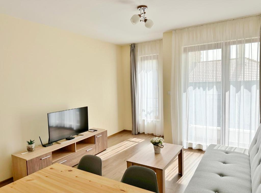 a living room with a couch and a tv and a table at Central Flat & Free Parking in Varna City
