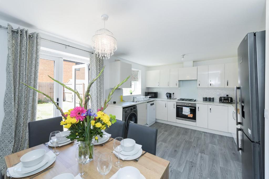 a kitchen and dining room with a table with flowers on it at Arkwright House - Modern Townhouse close to Nottingham City Centre in Nottingham