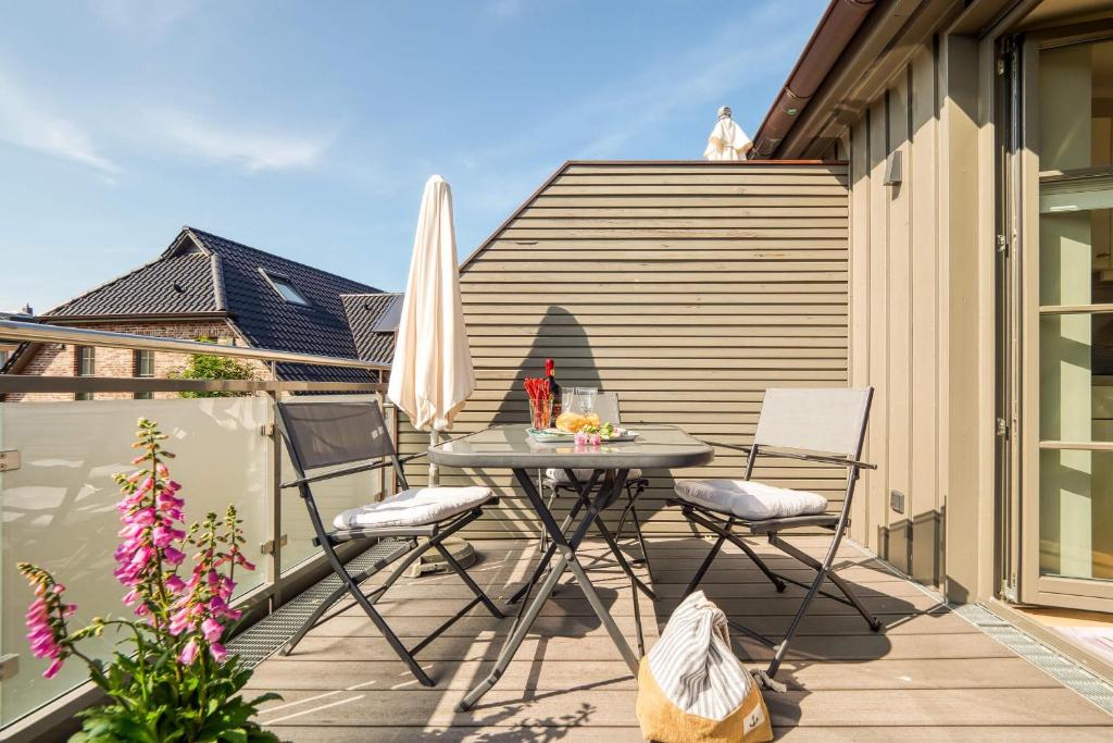 a patio with a table and chairs on a balcony at 54 Grad Nordost in Zingst