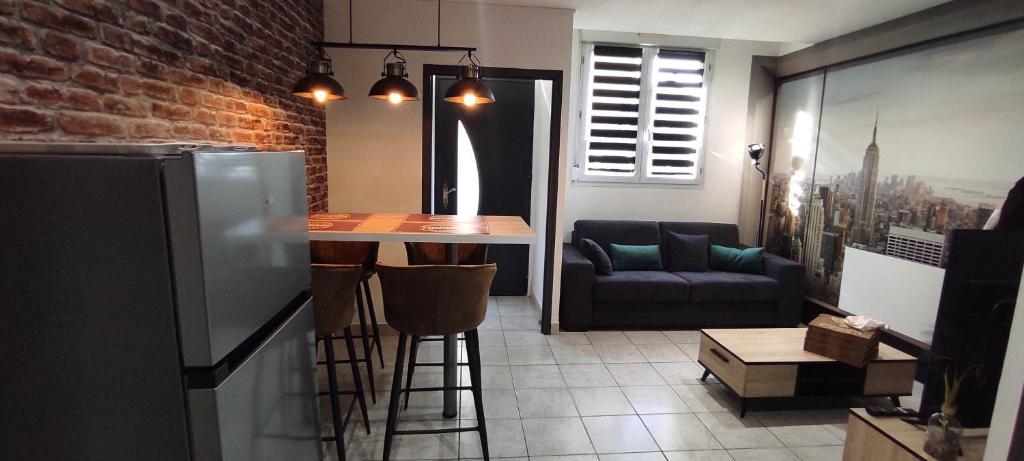 kuchnia ze stołem i kanapą w pokoju w obiekcie Chez Louis - Appartement Central w mieście Rethel