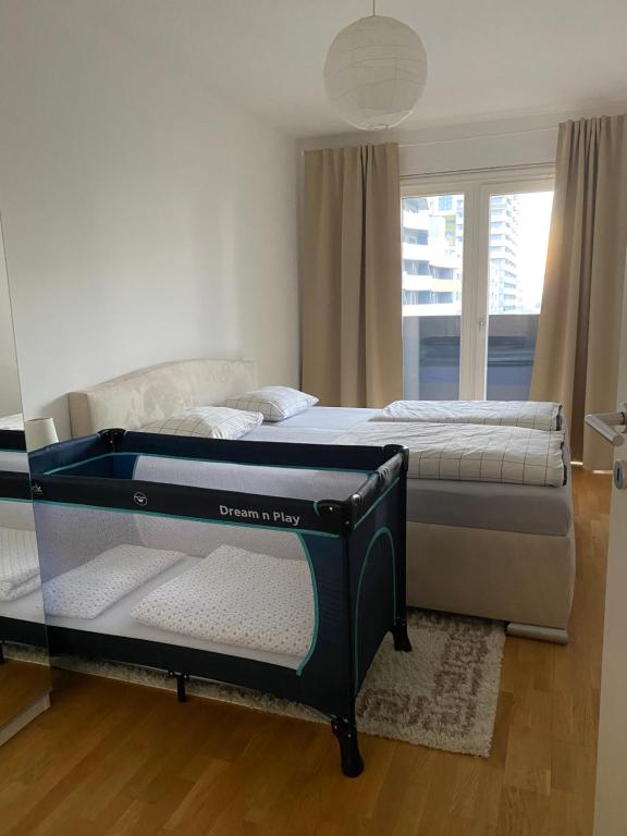 a bedroom with two beds and a window at 2 BR apartment next to metro U1 and Garage parking in Vienna