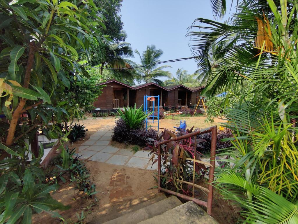 a house in the middle of a garden with trees at Pousada Donaciana - Beach Cottages in Baga
