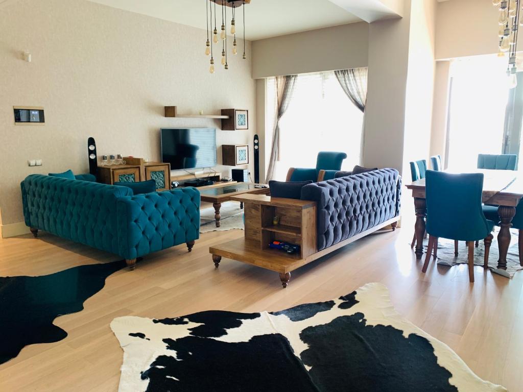 ein Wohnzimmer mit blauen Sofas und einem Tisch in der Unterkunft Luxury Flat for Embassies & GM in Ankara