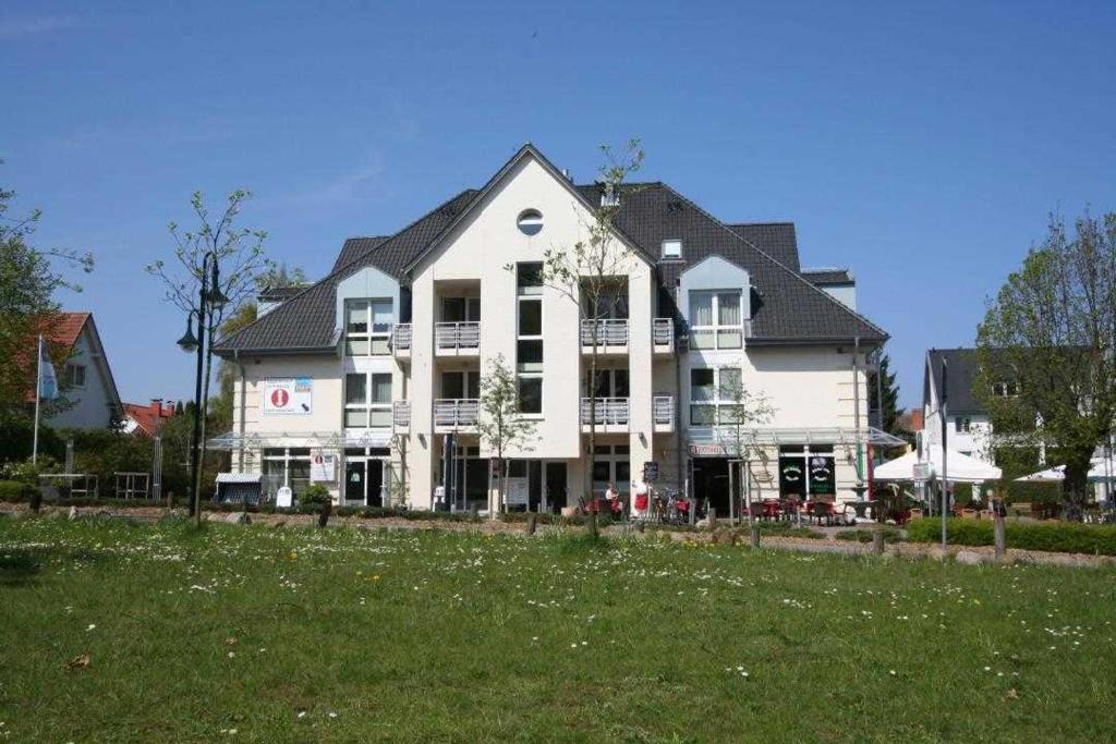 un gran edificio blanco con césped delante en Seestern Boltenhagen 2, en Olpenitz