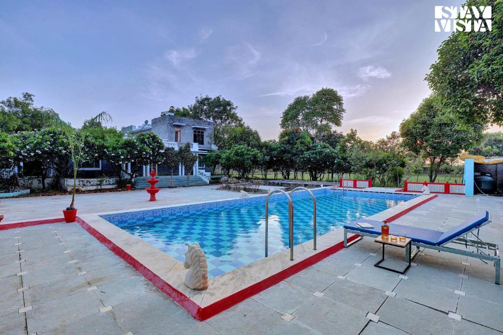 a large swimming pool with a blue table in the middle at Jungle Retreat by VEO - Part of StayVista in Bāli