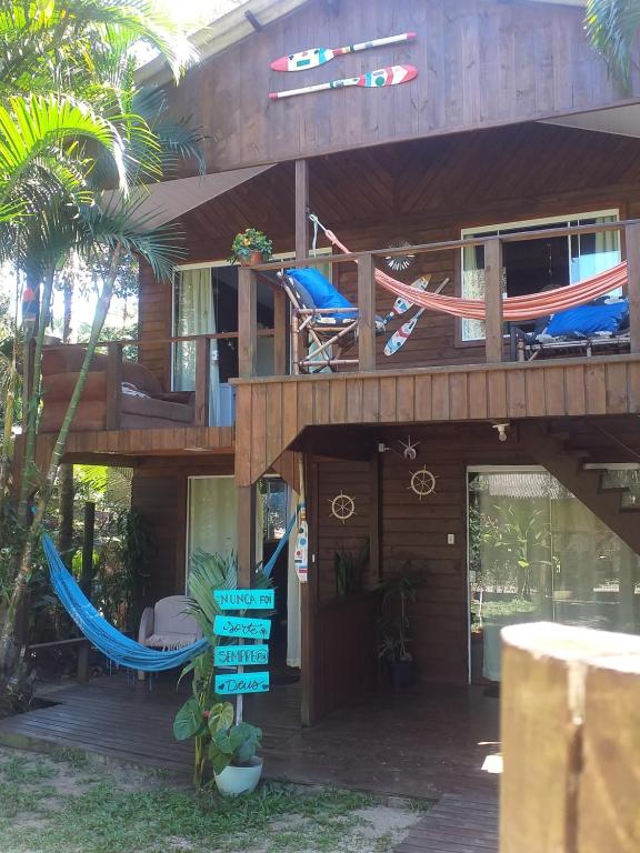 a house with a deck with a hammock on it at Suíte Solar in Ilha do Mel