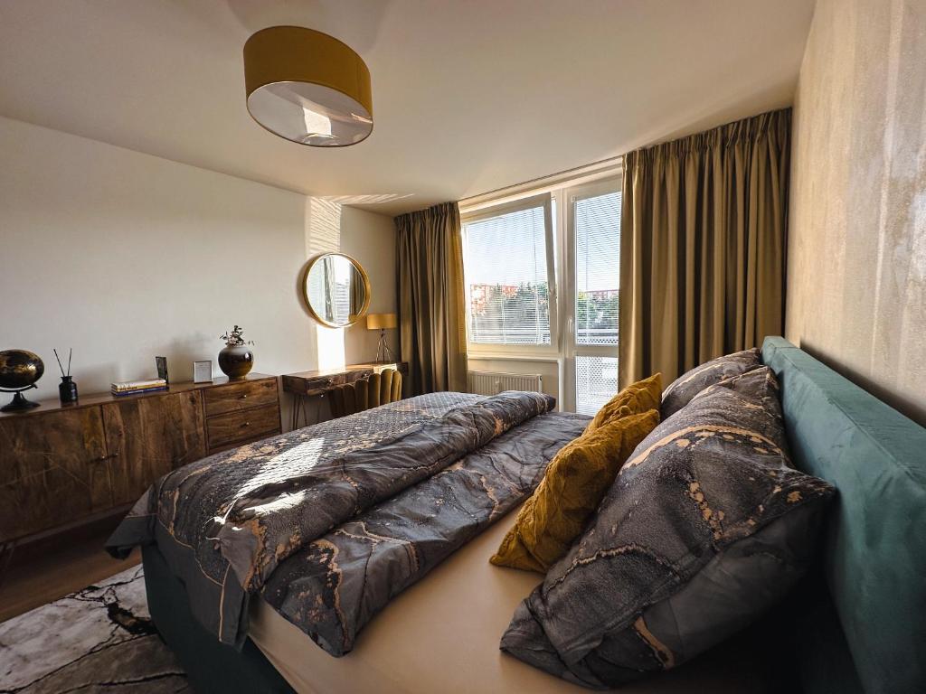 een slaapkamer met een groot bed en een groot raam bij City Comfort Retreat in Nové Zámky